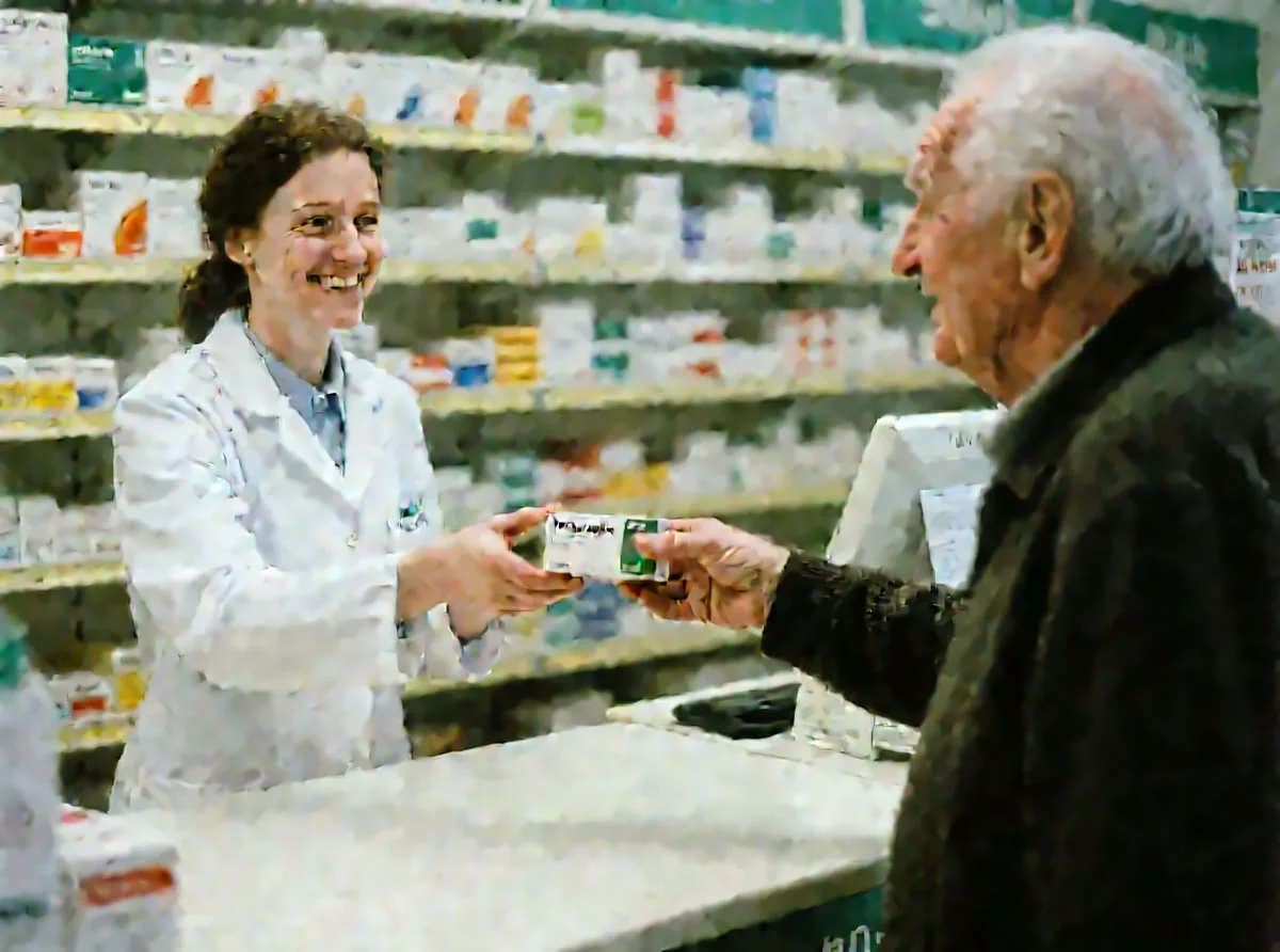 Foto A: In einer Apotheke gibt eine Apothekerin einem älteren Mann Medikamente.
